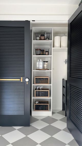 Laundry room with louvered doors and cubbyholes with baskets for storage