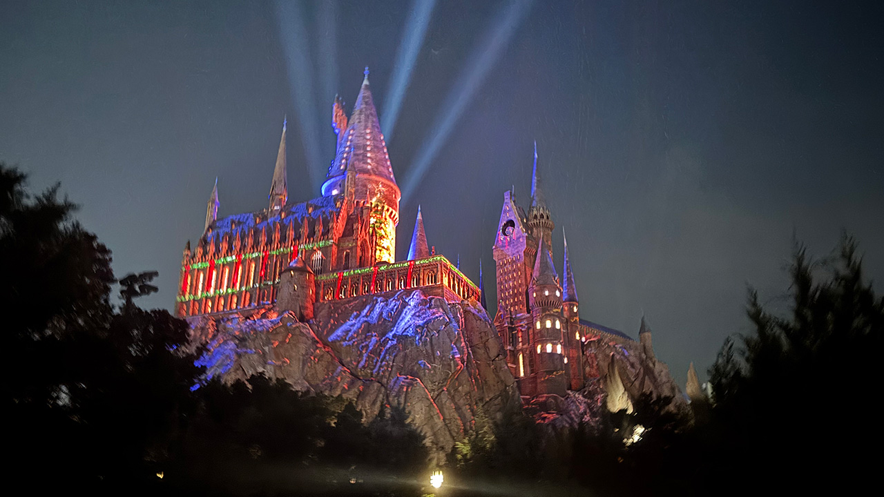 A look at Hogwarts&#039; Nighttime lights in Universal Studios November 2025, with spotlights lighting up the sky and projections on the castle.