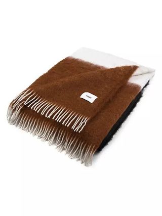 A wool blanket in brown and cream folded on a white background