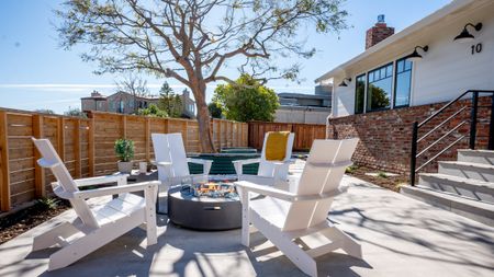 Retro Americana patio area by Studio SQUIRE styled with a trio of matte black outdoor gooseneck barn lights lining the exterior