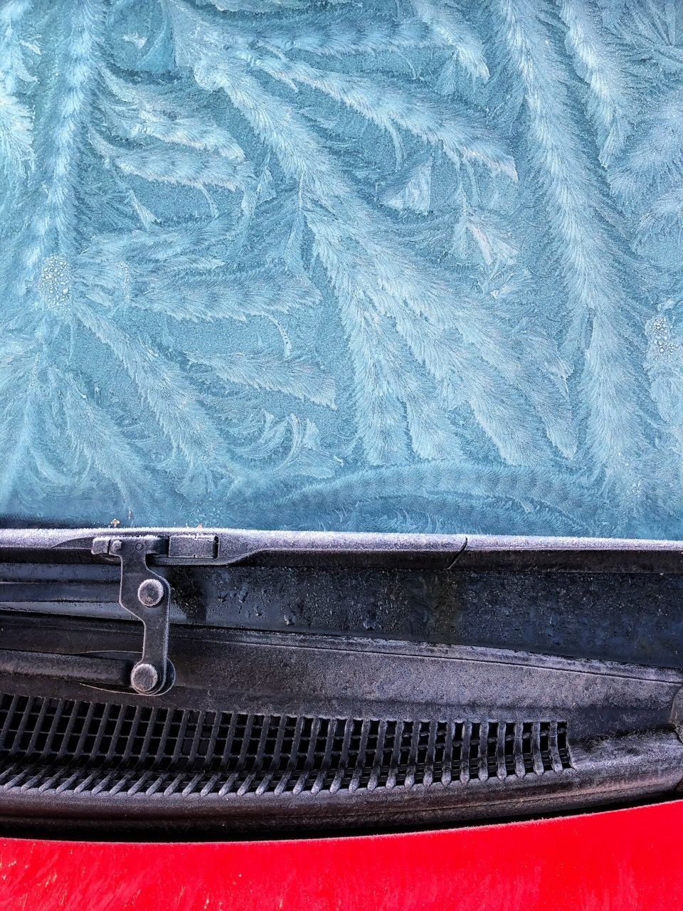 Close-up image of a pattern of frost on a car's windshield