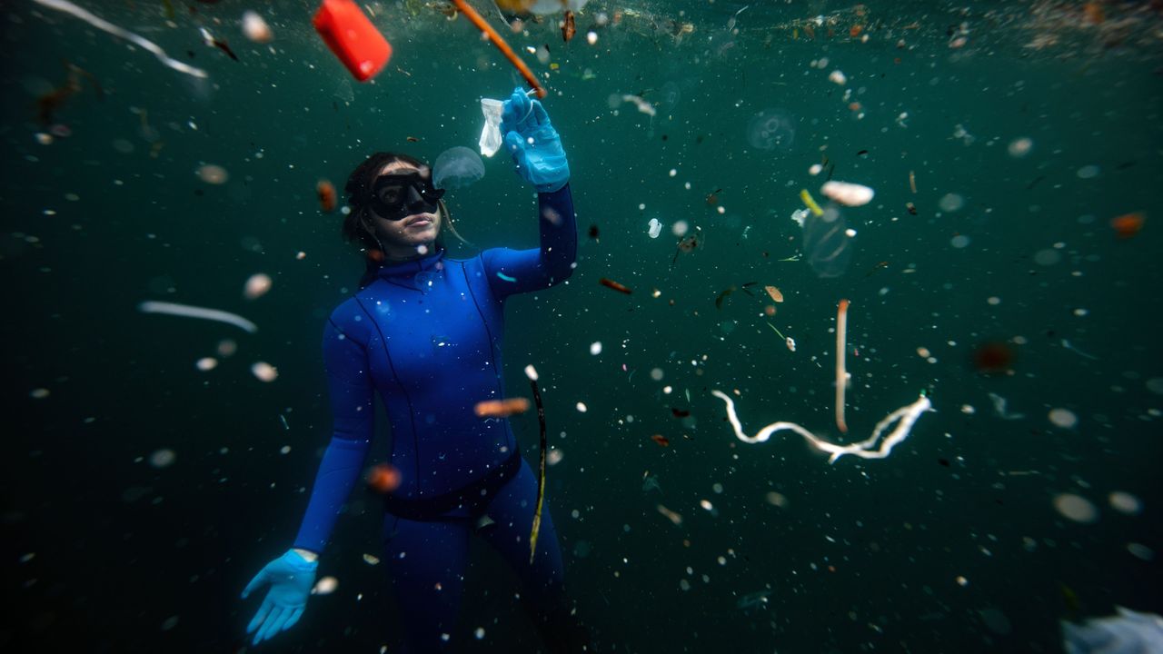 freediver swimming in polluted water