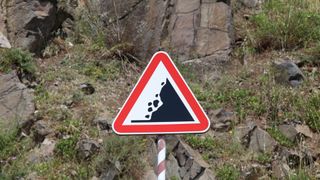 Landslide road sign against rock formation