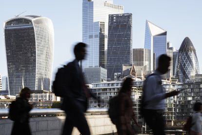 UK, London, blurred motion of incidental business people walking to work with view of the financial district behind