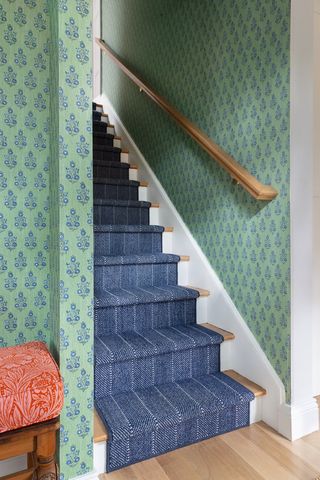 staircase with green patterned wallpaper