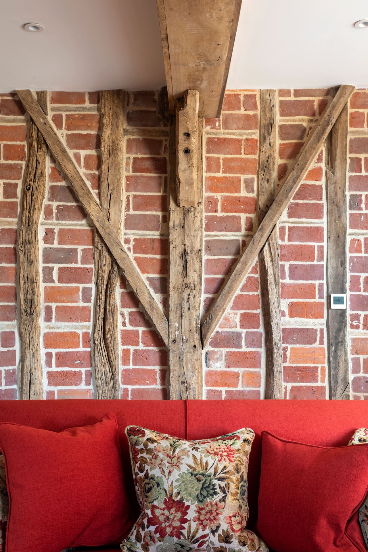 A brick and original timber wall inside a barn conversion