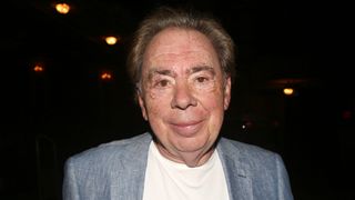 Sir Andrew Lloyd Webber wearing a suit and looking at the camera smiling