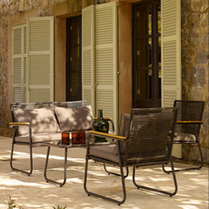 George Home Lisbon dining se on a patio in front of green french doors.