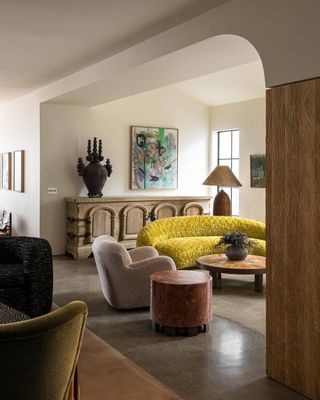 living room with a yellow sofa and neutral colored decor