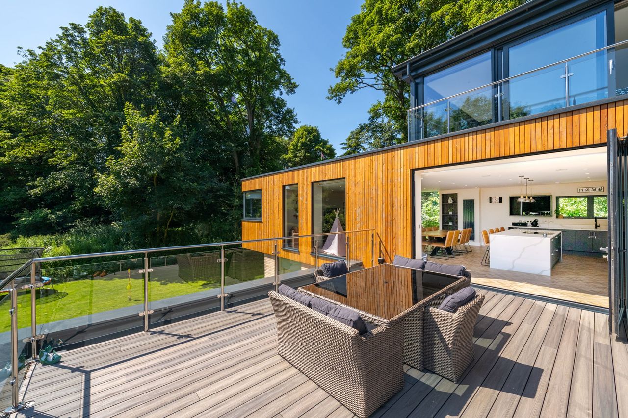 The balcony looks over the garden and into the kitchen on the second floor through bifold doors