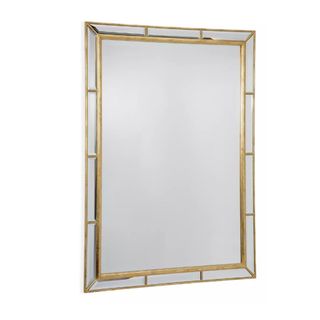 A rectangular mirror with a brushed gold beveled frame around the outside edges of it