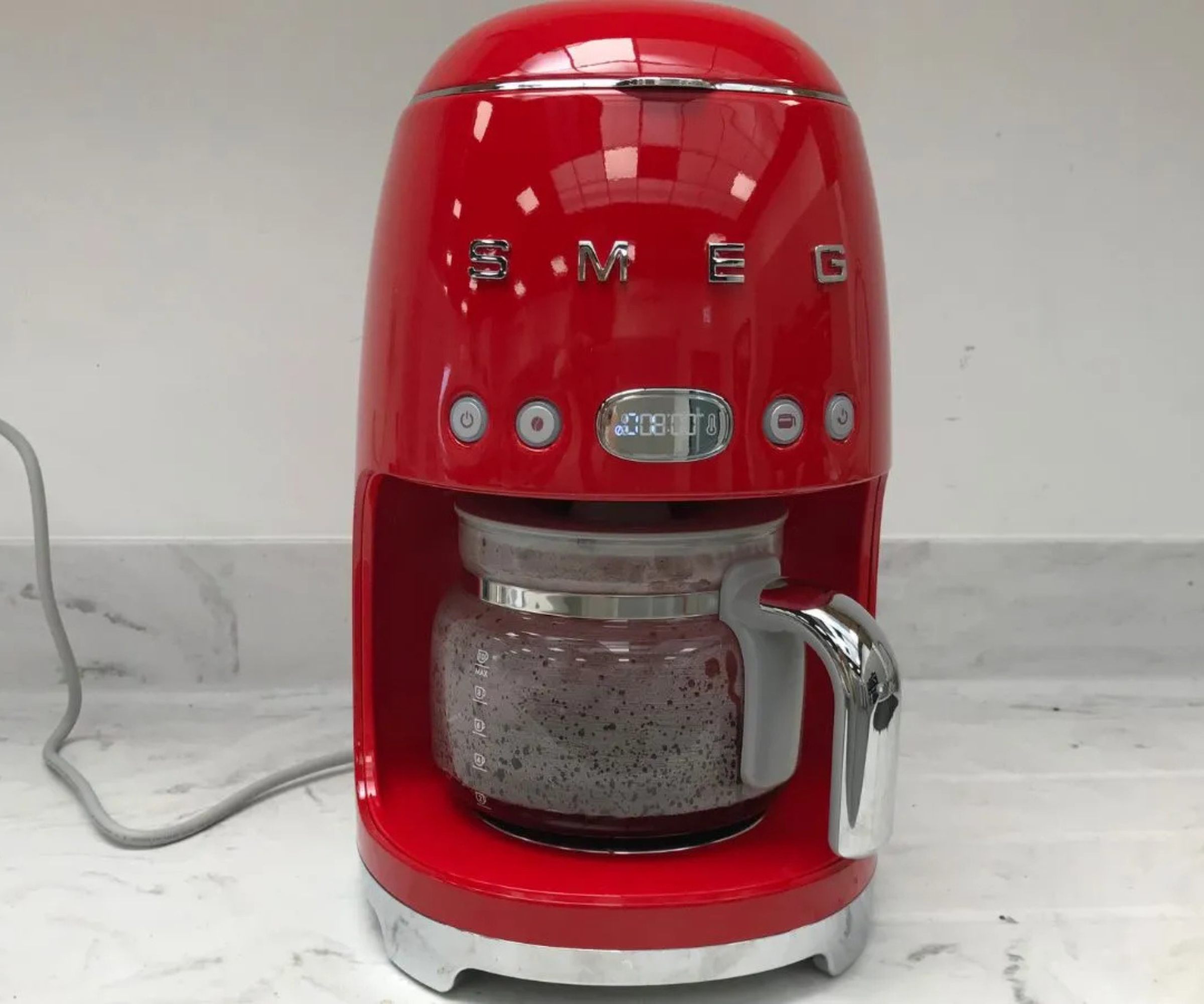 The red smeg drip coffee maker on a marble countertop