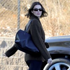 Kendal Jenner in leggings, Uggs, and a brown sweater. 
