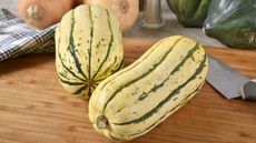 Delicata squash on a wooden chopping board