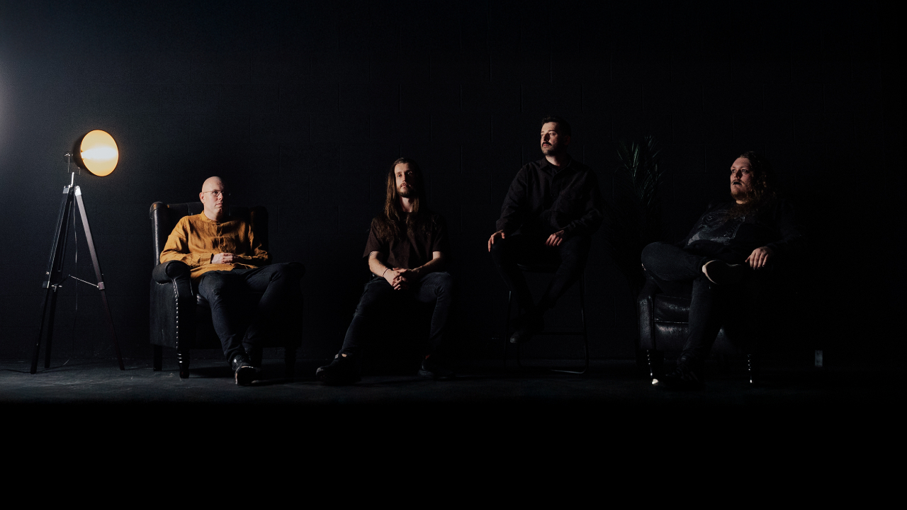 Conjurer sat in chairs against a black bakcground