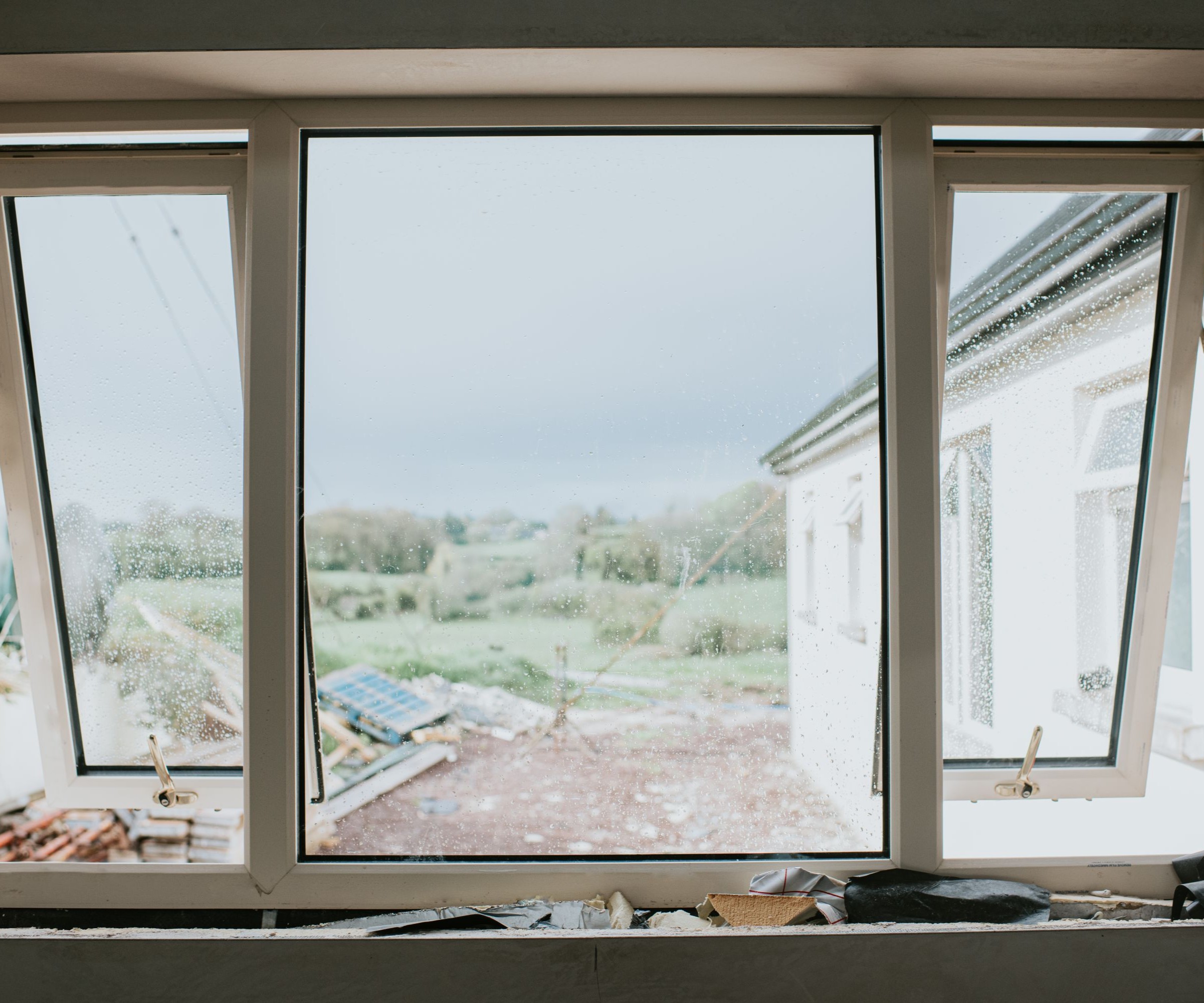 A large window with two parts that are open and a view of a building site