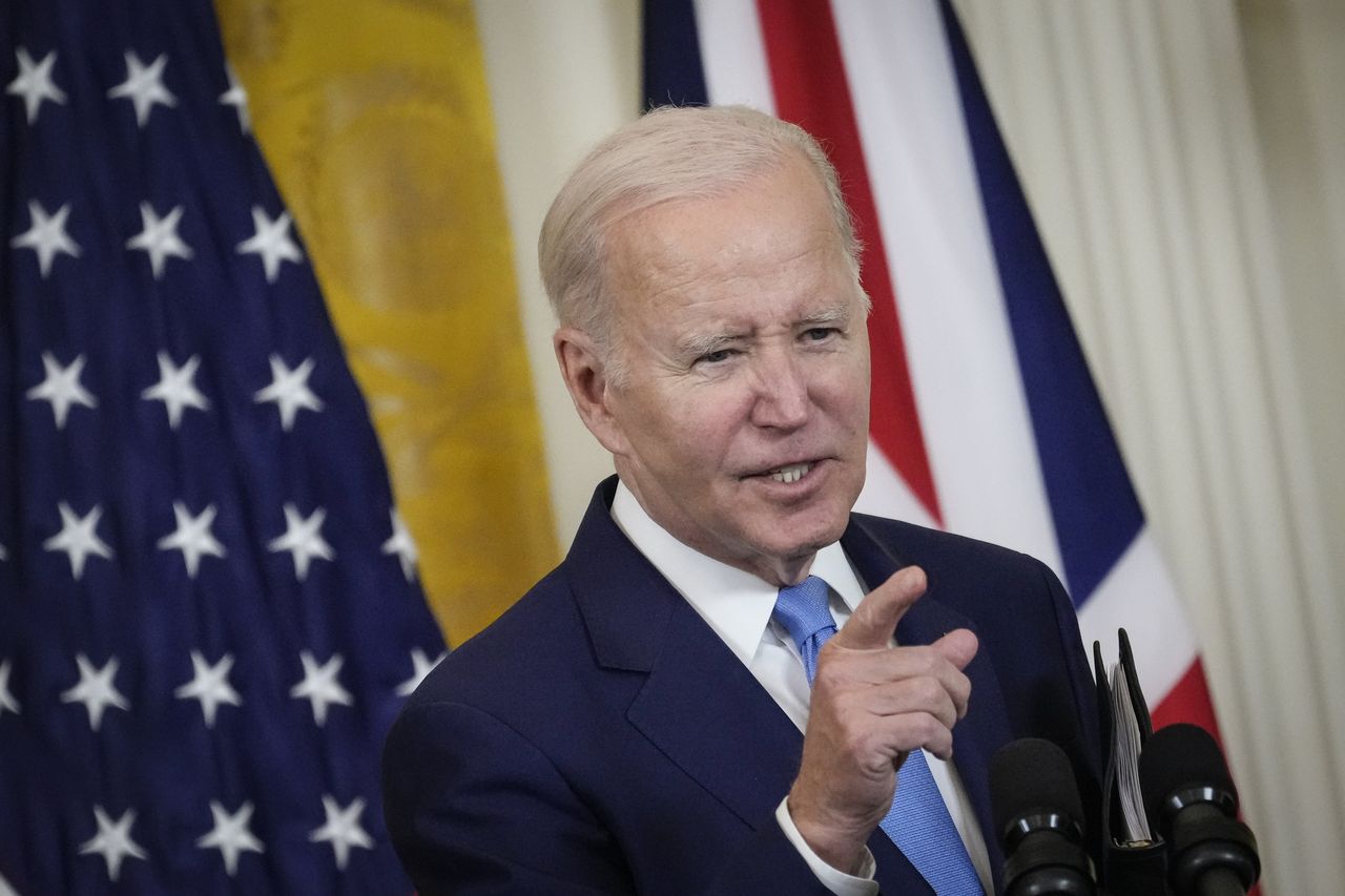 Biden speaks to the press with American and British flags behind him