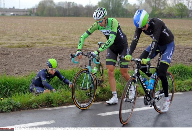 Jens Keukeleire (Orica-GreenEdge) and Maartern Wynants(Belkin) ride on while a Movistar rider watches from a ditch