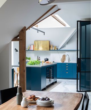blue kitchen with wooden table and roof light