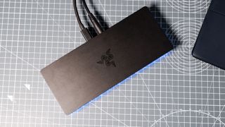 The Razer Thunderbolt 5 Dock on a desk with the RGB enabled and an SSD installed.