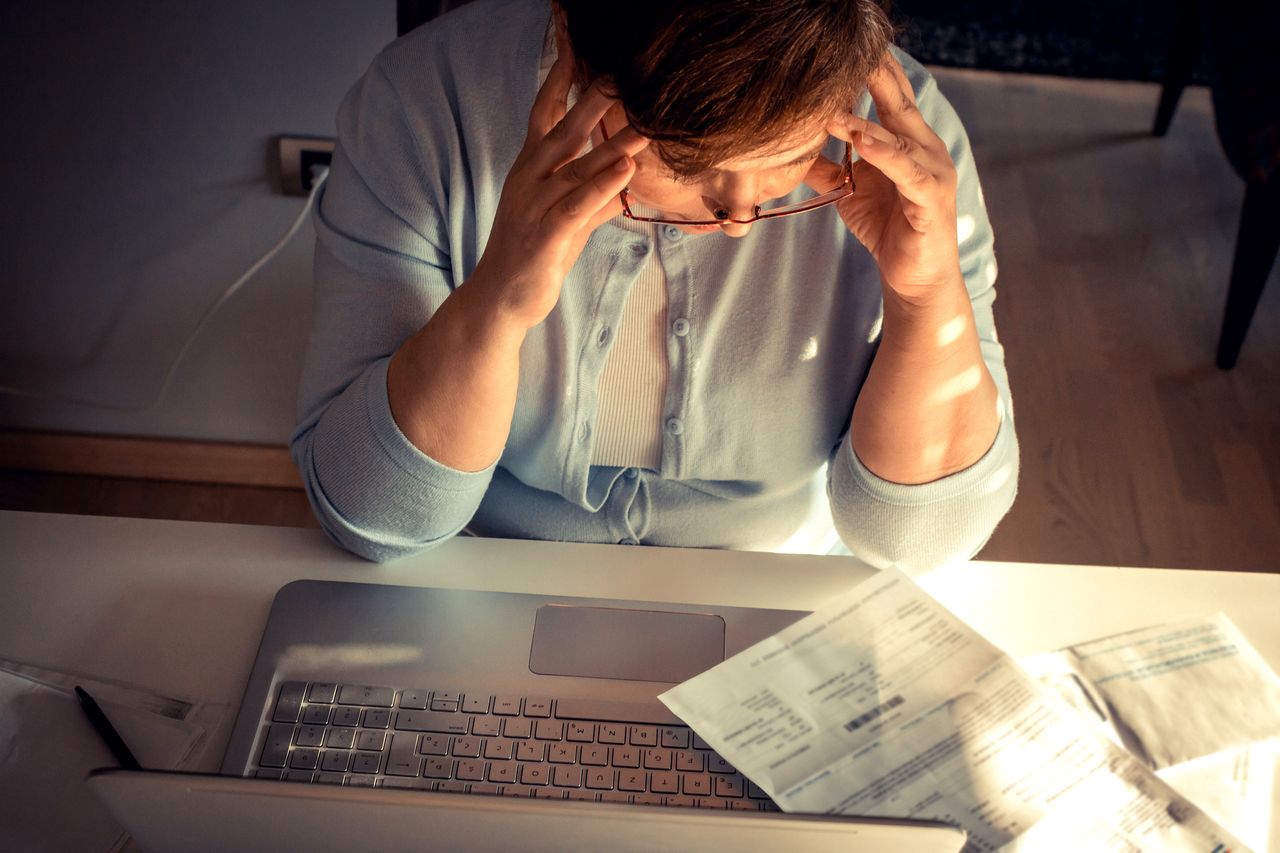 A woman looking at bills.