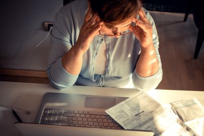 A woman looking at bills.