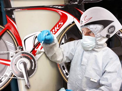 Dr Hutch cleans a bike to in a white suit