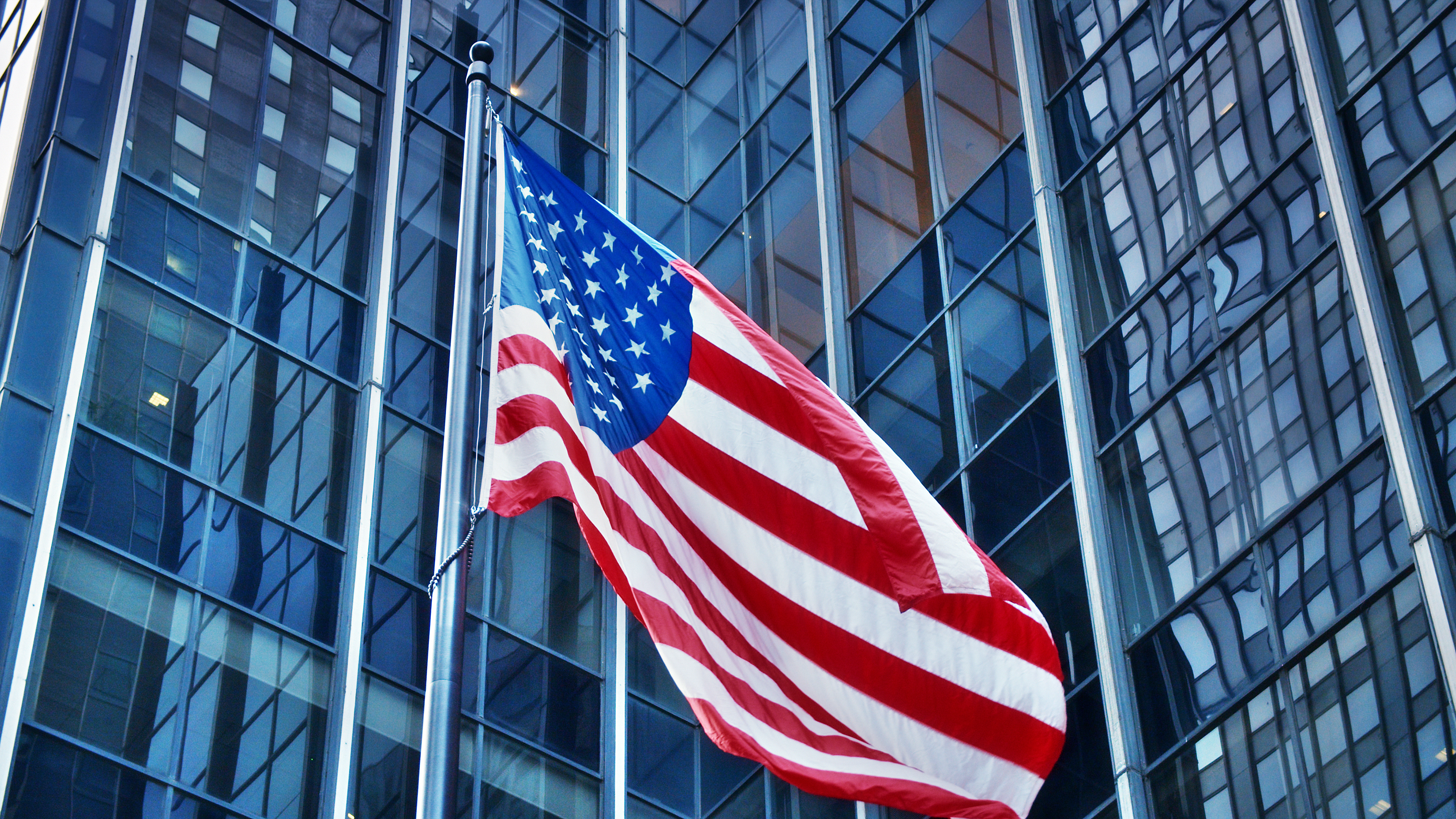 Amerikanisches Geschäft.  Amerikanische Flagge, modernes Finanzgebäude, konzeptionelle Sicht