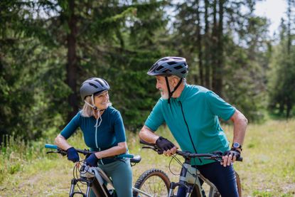 Senior couple bike riding in during their summer holiday