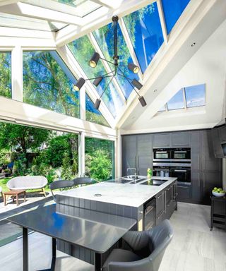 contemporary kitchen conservatory with angled roof and grey kitchen