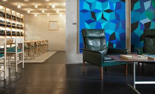 Green leather armchairs in front of blue wall art