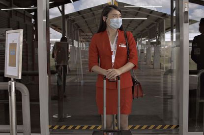 A flight attendant wears a face mask.