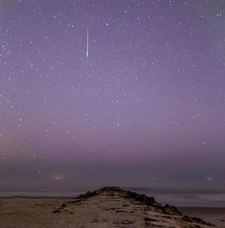 A bright Perseid meteor darts through a purple sky early Monday morning (Aug. 12) in this shot by astrophotographer Chris Bakley in Stone Harbor, New Jersey. In the distance about halfway down the photo, another fainter meteor can be seen dashing to the left.