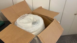 The REM-Fit 500 Ortho Hybrid mattress rolled up in its box