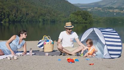 best beach tent: BabyMoov Anti-UV tent with family on lakeside
