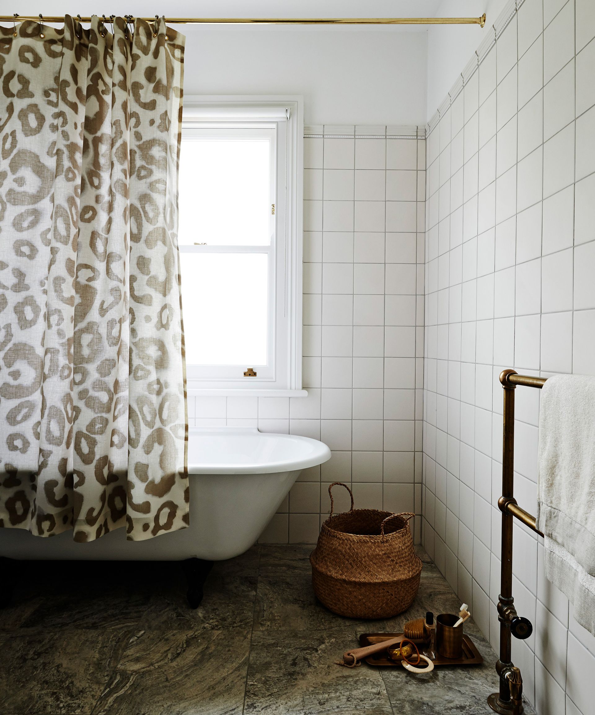 A white bathroom with a freestanding bath and an animal print shower curtain
