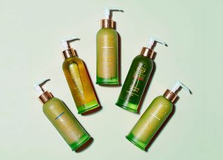 Tata harper skincare in green glass bottles against green background
