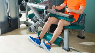 Man using leg curl machine in gym
