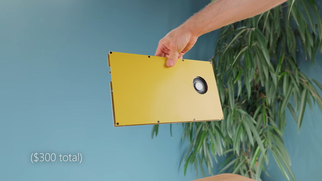 Hand holding yellow mini PC made from RTX 4060 laptop motherboard.