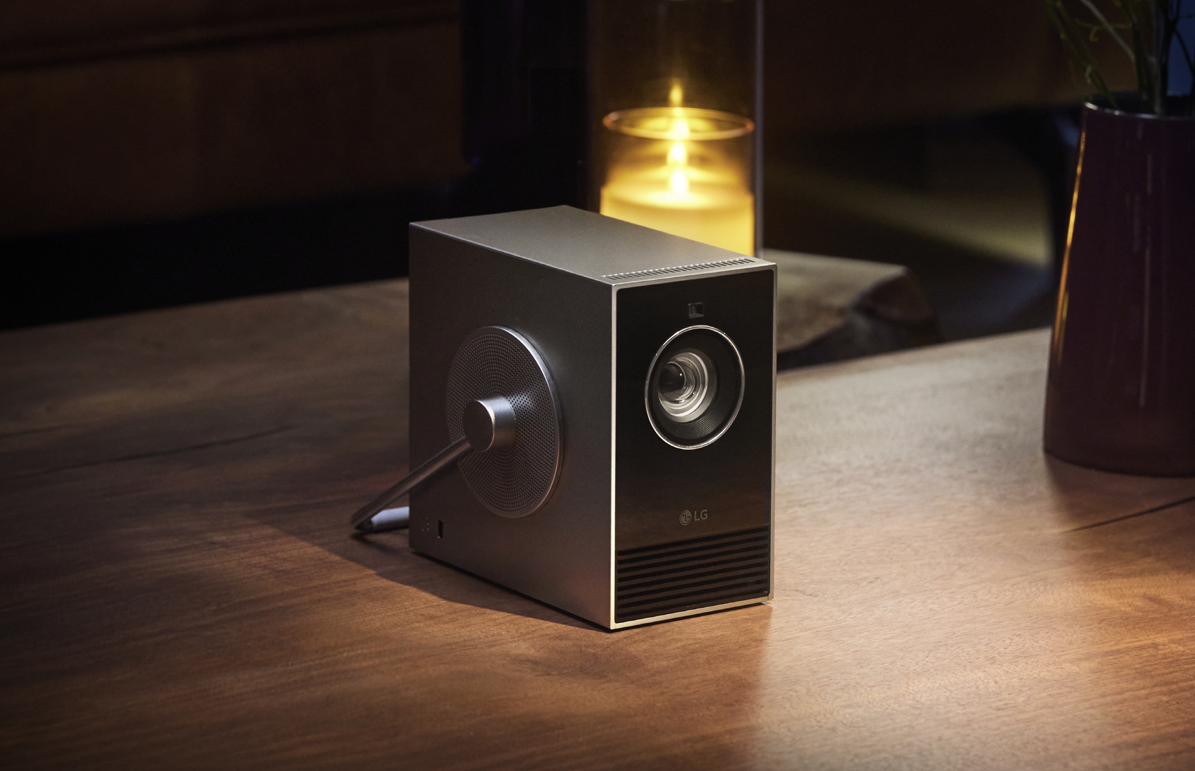 LG CineBeam Qube 4K portable projector on wood table 