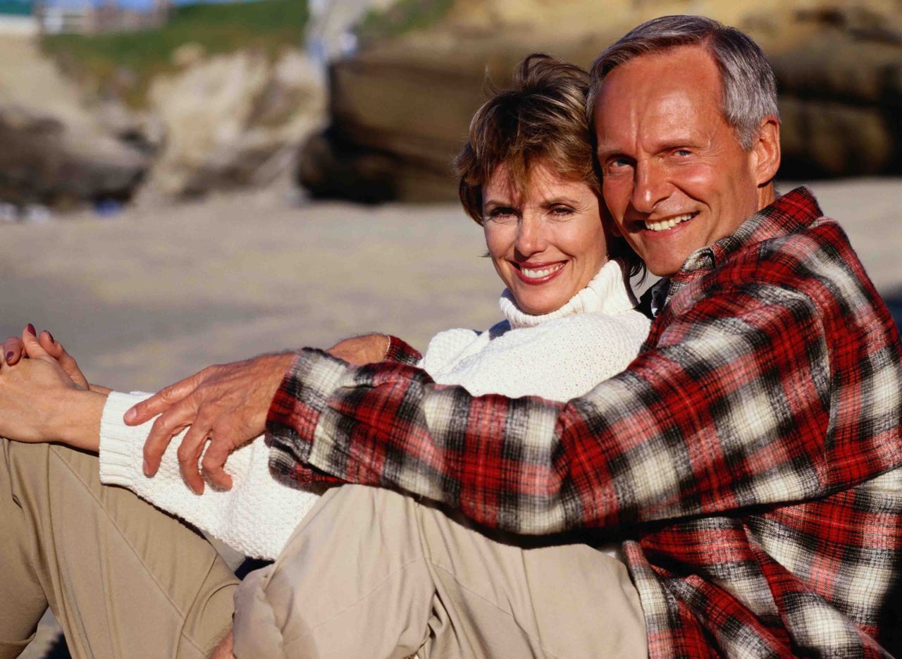 A couple cuddling on the beach. 