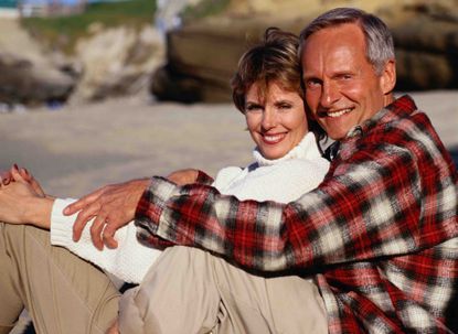 A couple cuddling on the beach. 