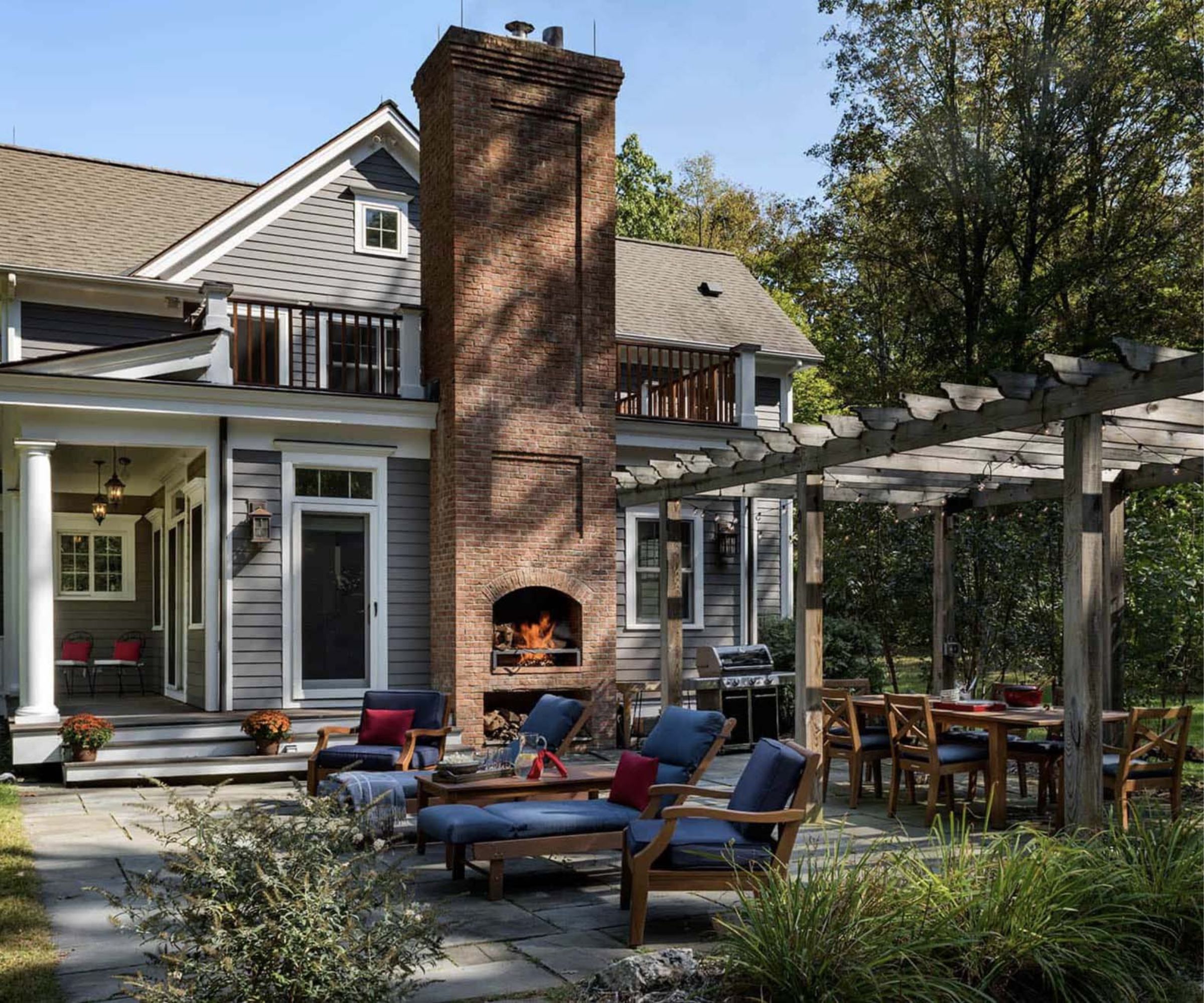 Outdoor fireplace with pergola, wood seating and patio