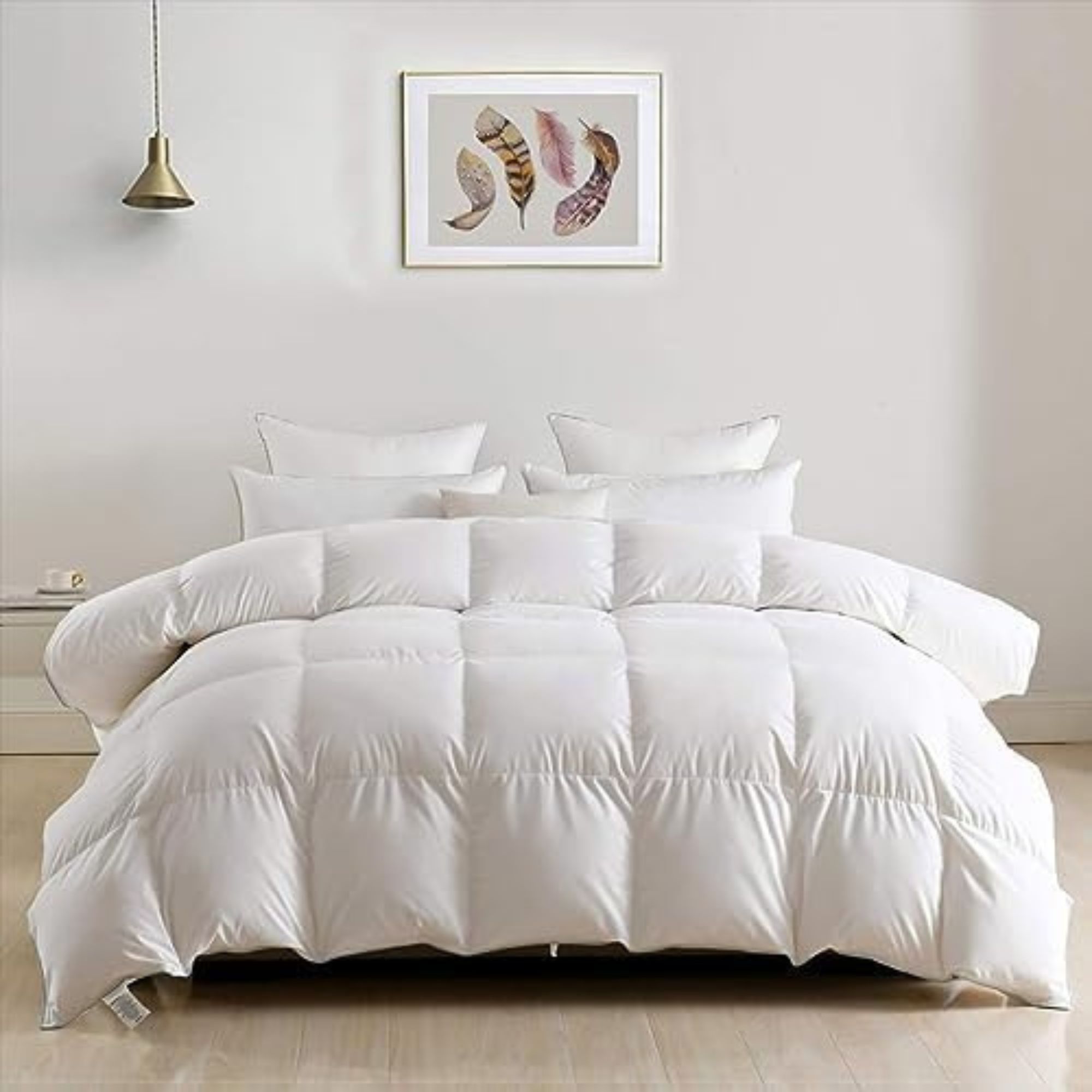 DWR Luxury King Down Comforter on a bed against a white wall.