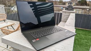 A black Acer Swift Edge 16 laptop sitting on a garden wall