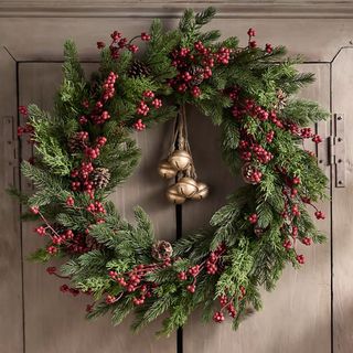 An Anthropologie Faux Pine Berry Wreath on a door