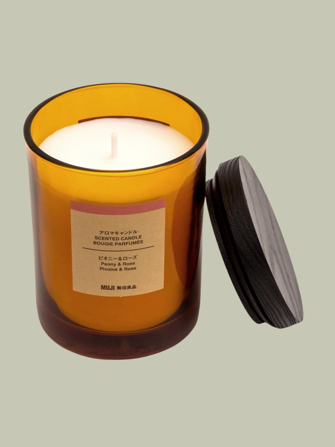 An amber glass peony and rose candle from MUJI
