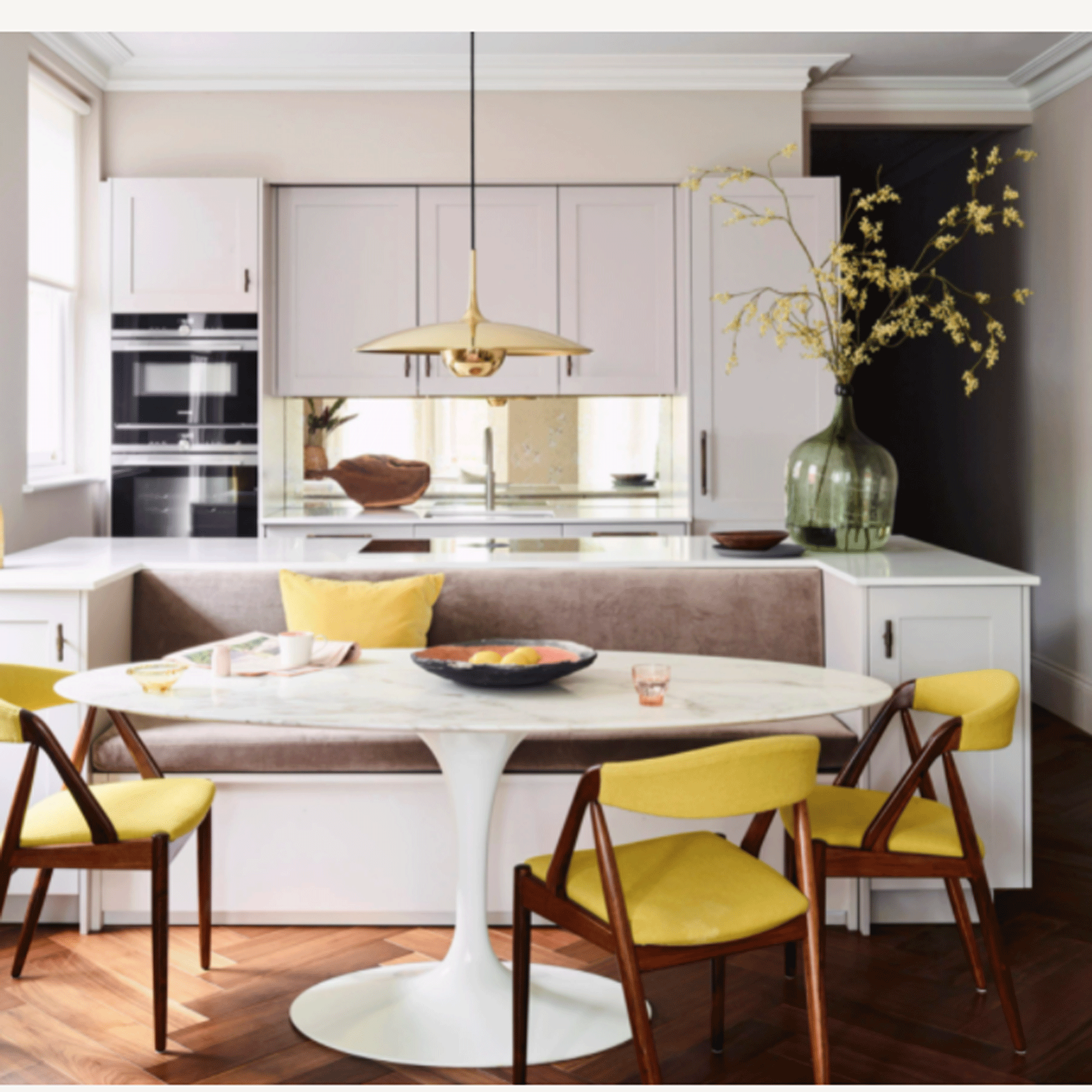 Banquette seating in kitchen with bright yellow chairs