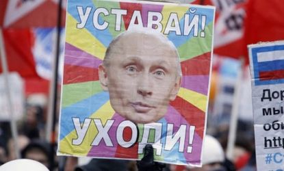 A Russian protester holds a sign that reads "Get Tired! Leave!"