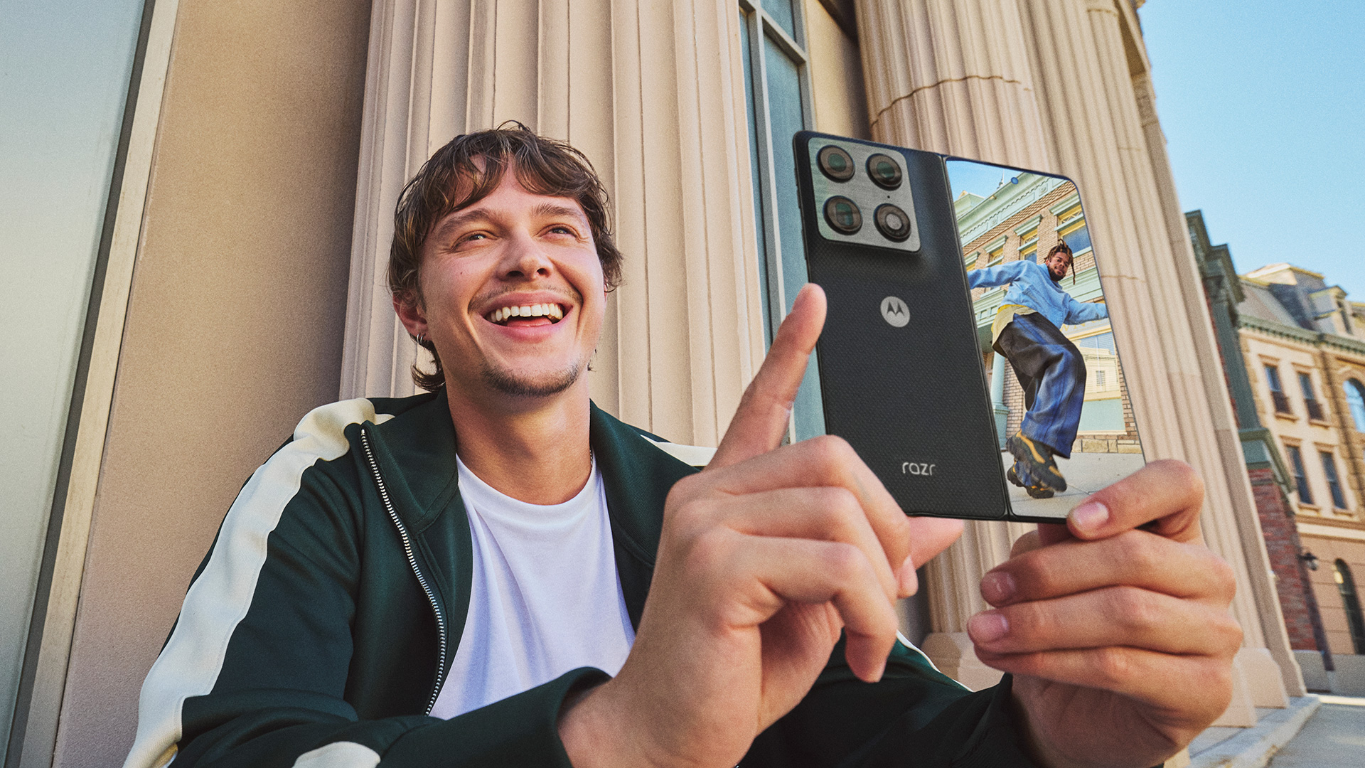 Man using the Motorola Razr Fold to take a photo of his posing friend